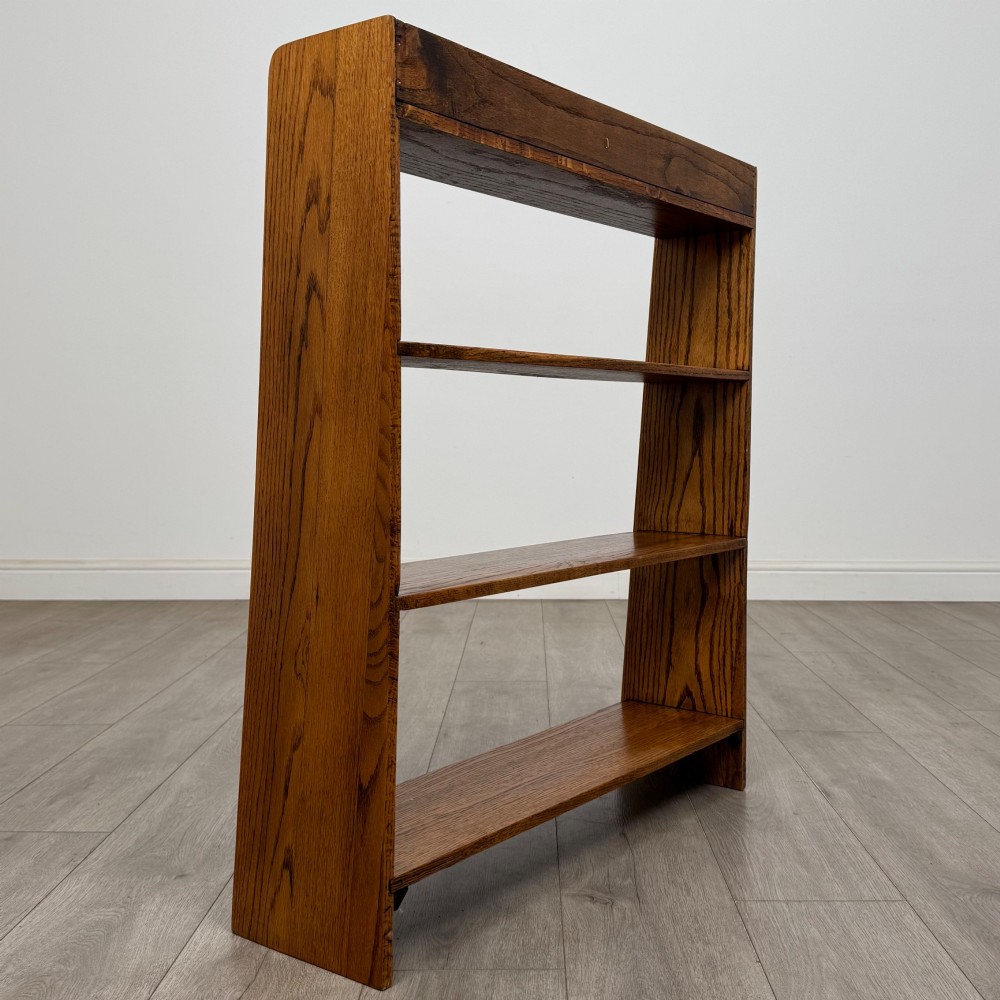 An open golden oak bookcase featuring four horizontal shelves arranged vertically with solid side panels. View V