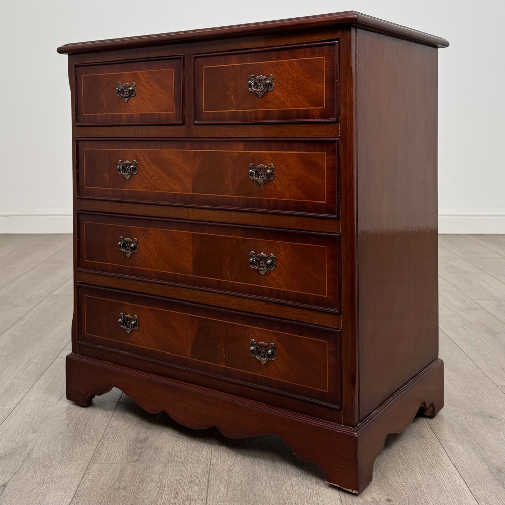 A 20th-century inlaid mahogany chest of drawers featuring two short over three long drawers with decorative brass handles. View II