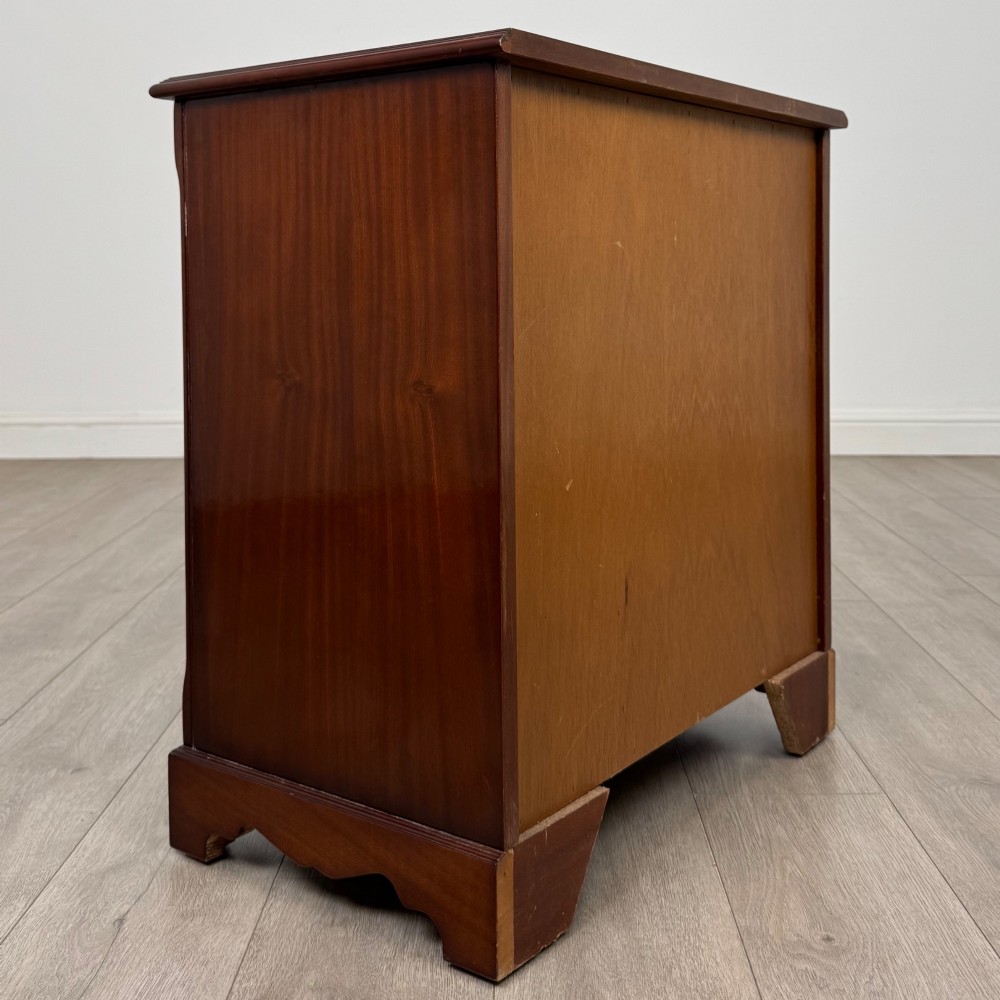 A 20th-century inlaid mahogany chest of drawers featuring two short over three long drawers with decorative brass handles. View IV