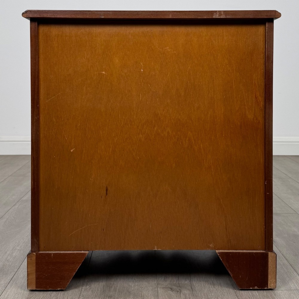 A 20th-century inlaid mahogany chest of drawers featuring two short over three long drawers with decorative brass handles. View V
