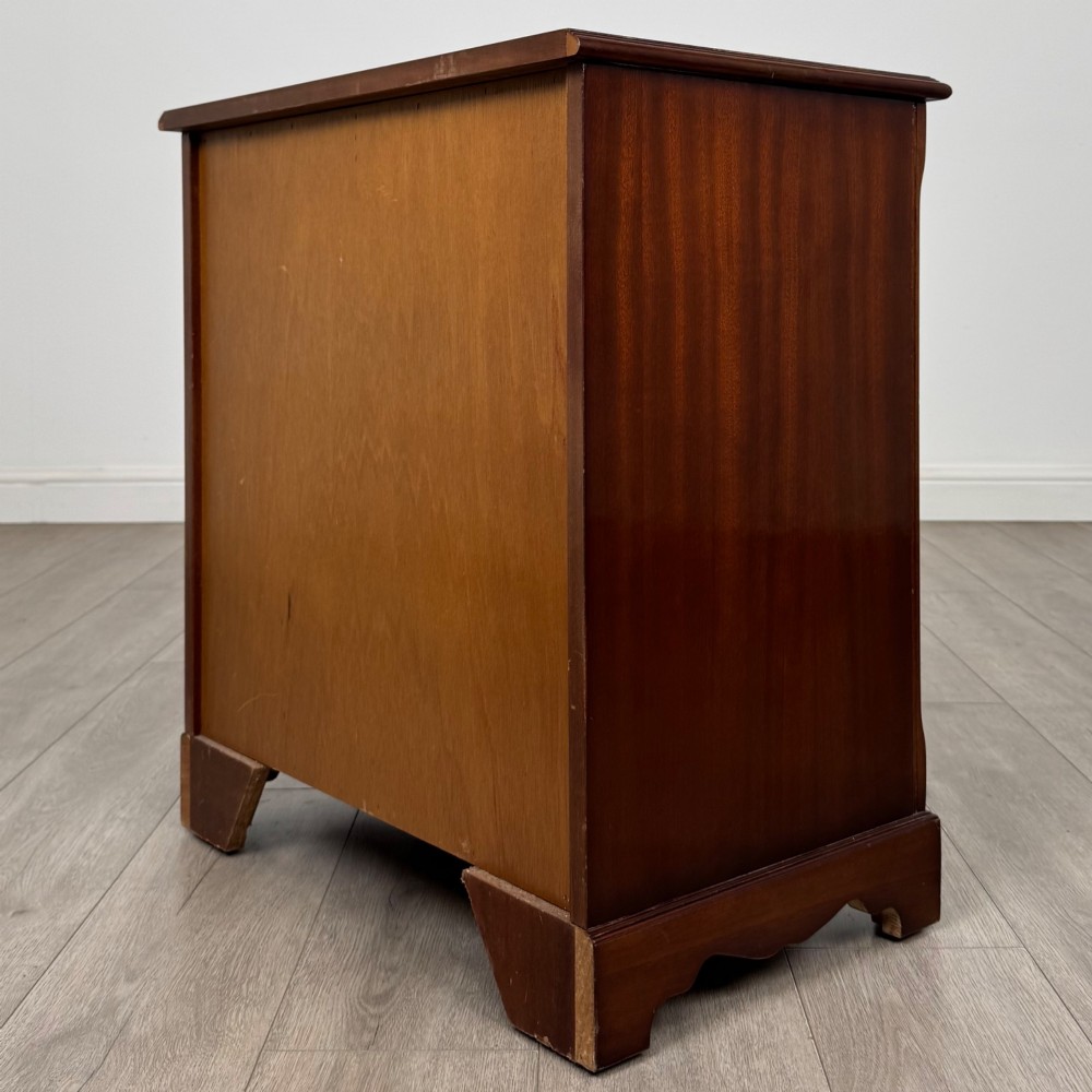 A 20th-century inlaid mahogany chest of drawers featuring two short over three long drawers with decorative brass handles. View VI