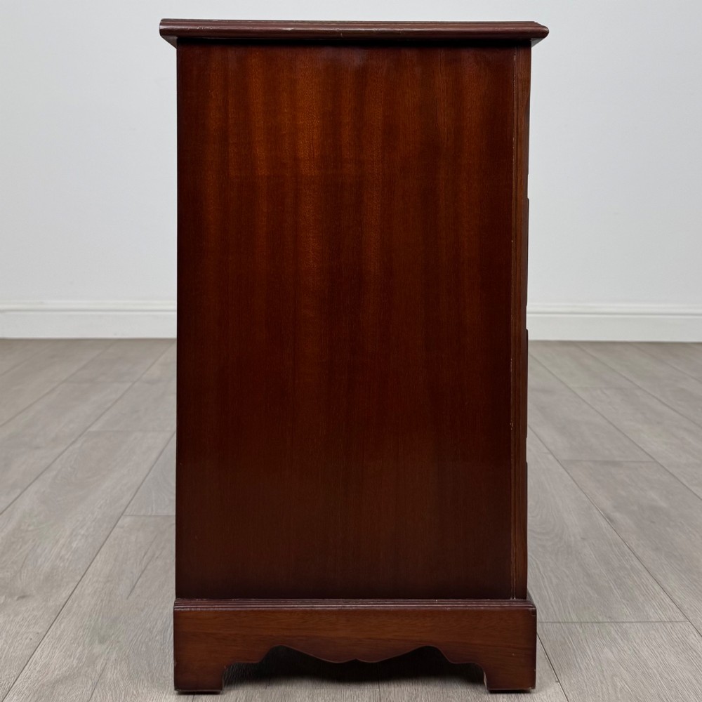 A 20th-century inlaid mahogany chest of drawers featuring two short over three long drawers with decorative brass handles. View VII