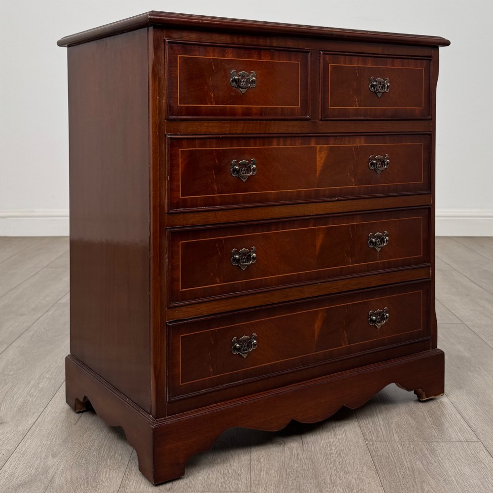 A 20th-century inlaid mahogany chest of drawers featuring two short over three long drawers with decorative brass handles. View VIII