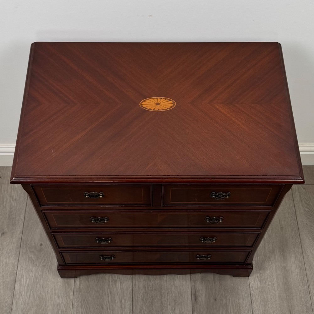 A 20th-century inlaid mahogany chest of drawers featuring two short over three long drawers with decorative brass handles. View IX