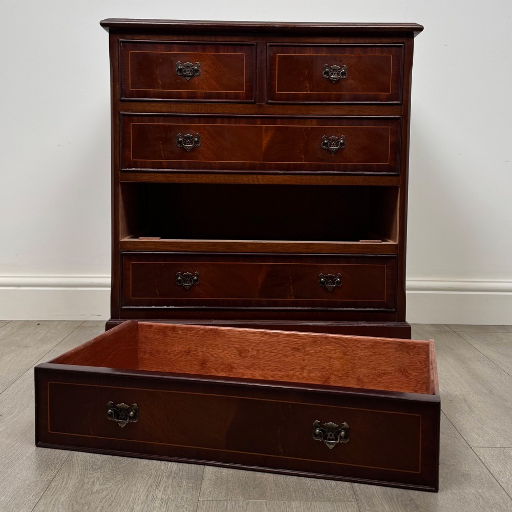 A 20th-century inlaid mahogany chest of drawers featuring two short over three long drawers with decorative brass handles. View X