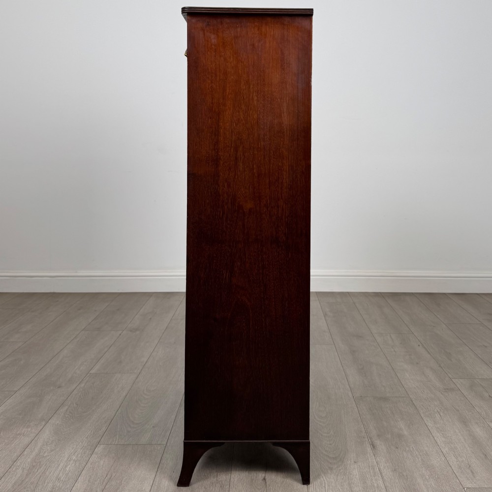 A tall 19th-century Regency mahogany open bookcase featuring four open shelves, a top drawer with twin brass knobs, and flared feet. View IV