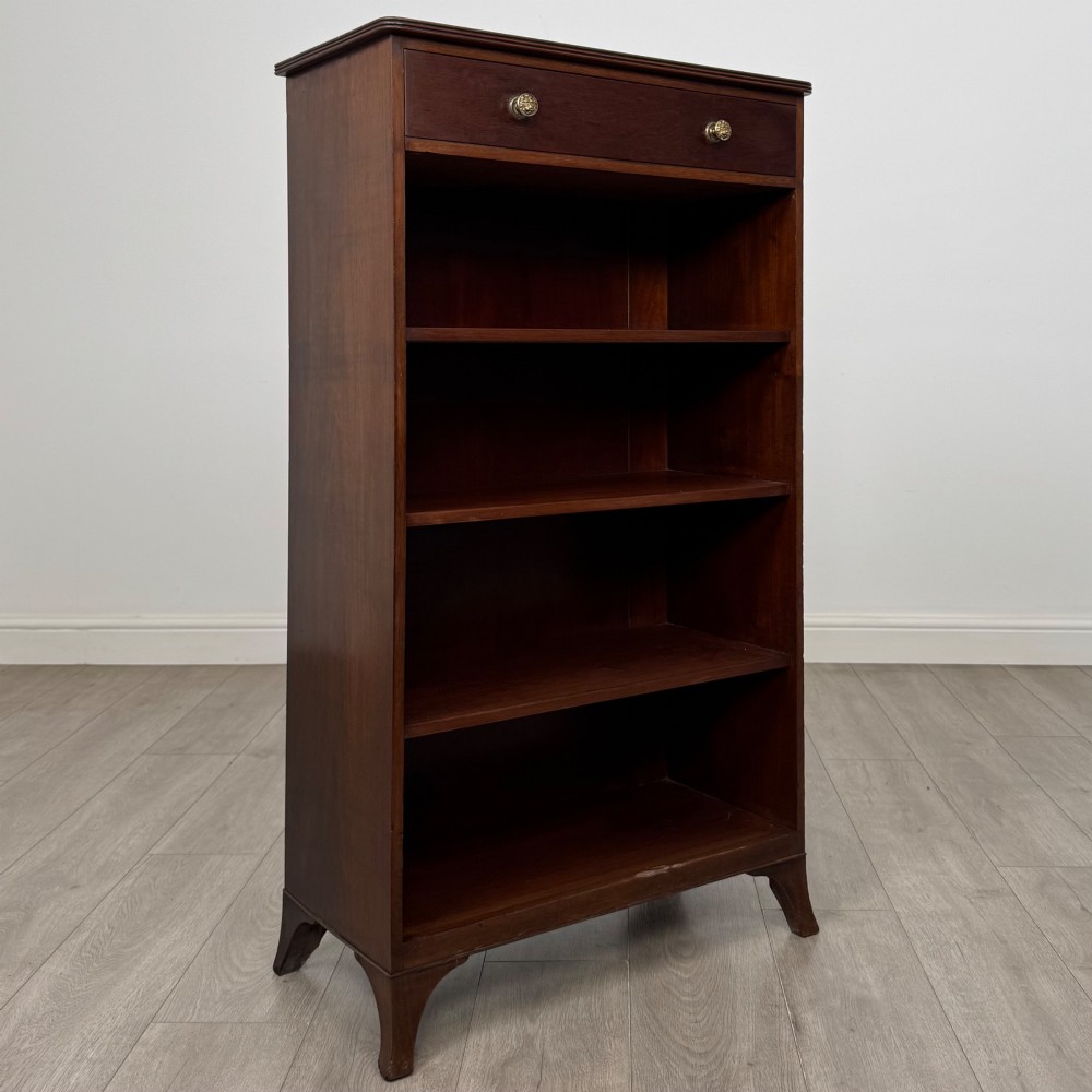 A tall 19th-century Regency mahogany open bookcase featuring four open shelves, a top drawer with twin brass knobs, and flared feet. View IX