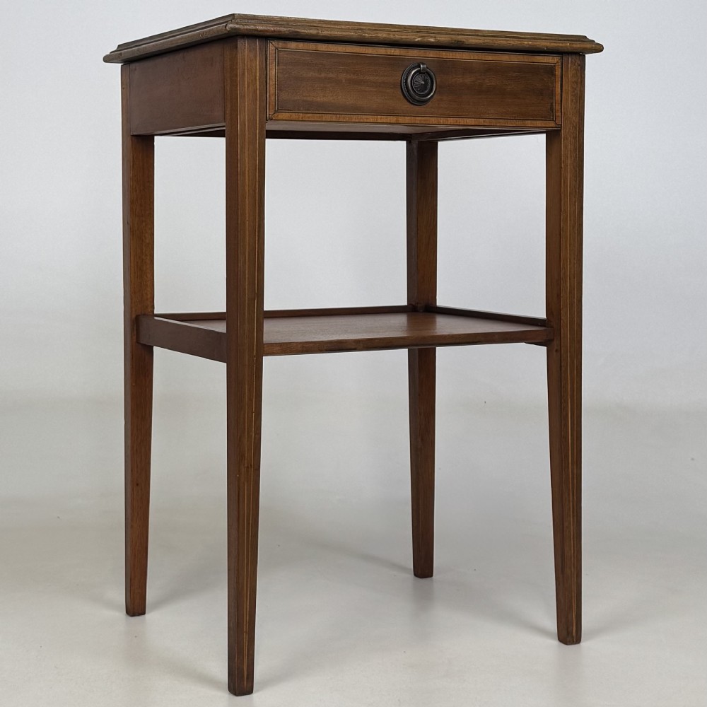 A pair of tall, slim mahogany bedside tables with single top drawers, round brass ring handles, open lower shelves, and tapered legs. View IX