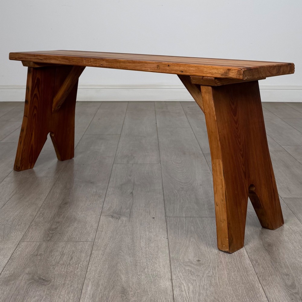 A pitch pine wooden bench with angled trestle legs, diagonal side braces, and a reeded edge along the top rectangular seat. View V