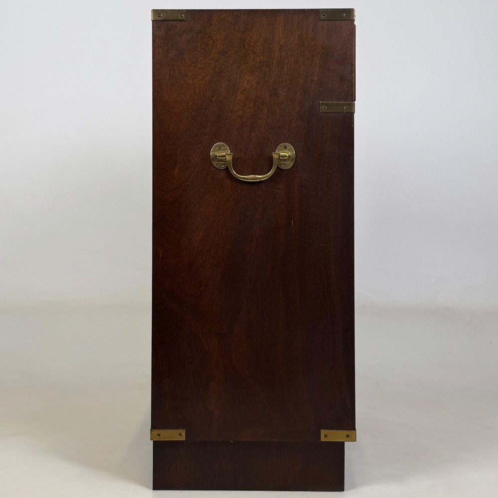 A dark mahogany campaign style cabinet featuring a single upper drawer with a flush brass handle, brass corner mounts, and two open lower shelves. View VIII