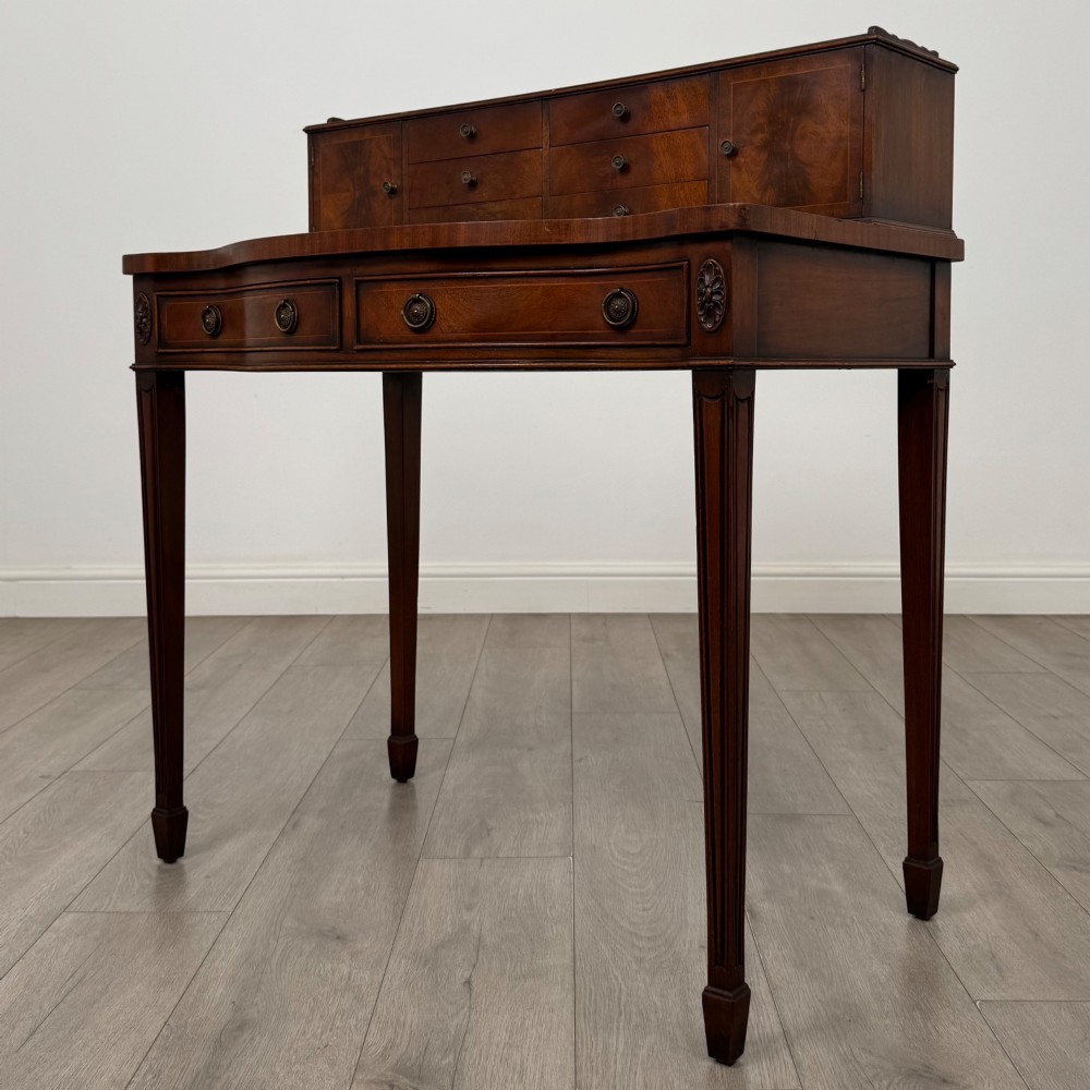 A mahogany writing table featuring a raised superstructure with small drawers and side cupboards above two main frieze drawers, supported by square tapered fluted legs. View II