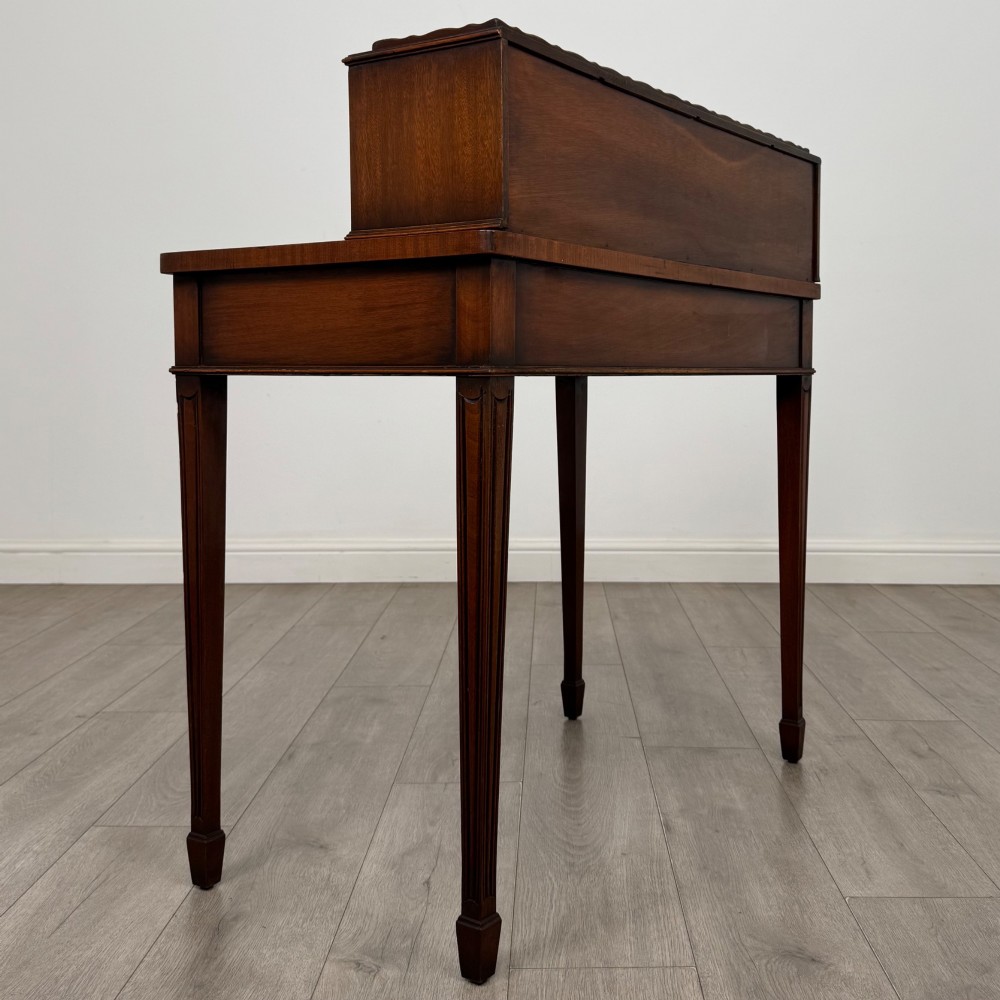 A mahogany writing table featuring a raised superstructure with small drawers and side cupboards above two main frieze drawers, supported by square tapered fluted legs. View IV