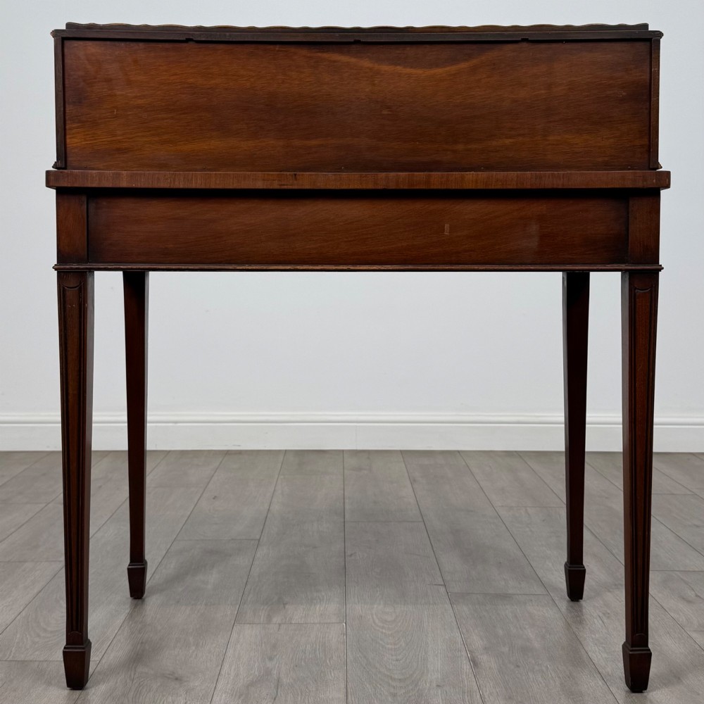 A mahogany writing table featuring a raised superstructure with small drawers and side cupboards above two main frieze drawers, supported by square tapered fluted legs. View V