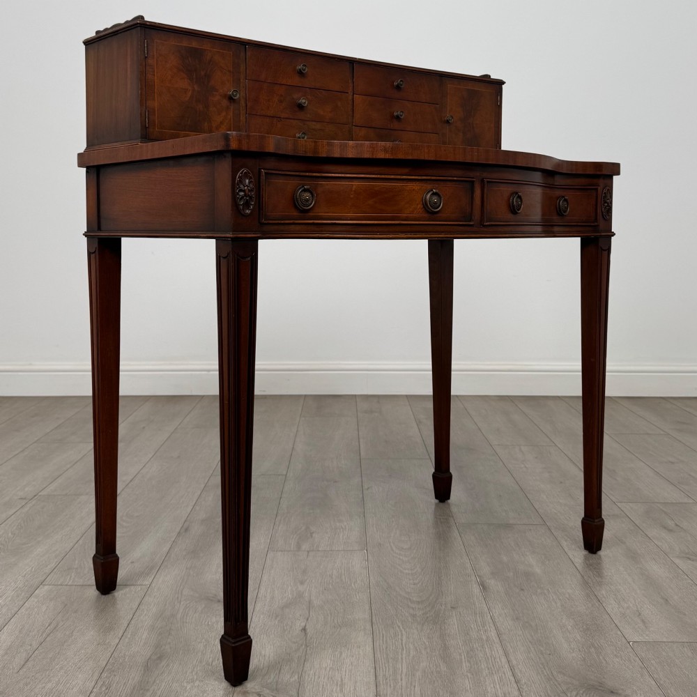A mahogany writing table featuring a raised superstructure with small drawers and side cupboards above two main frieze drawers, supported by square tapered fluted legs. View VIII