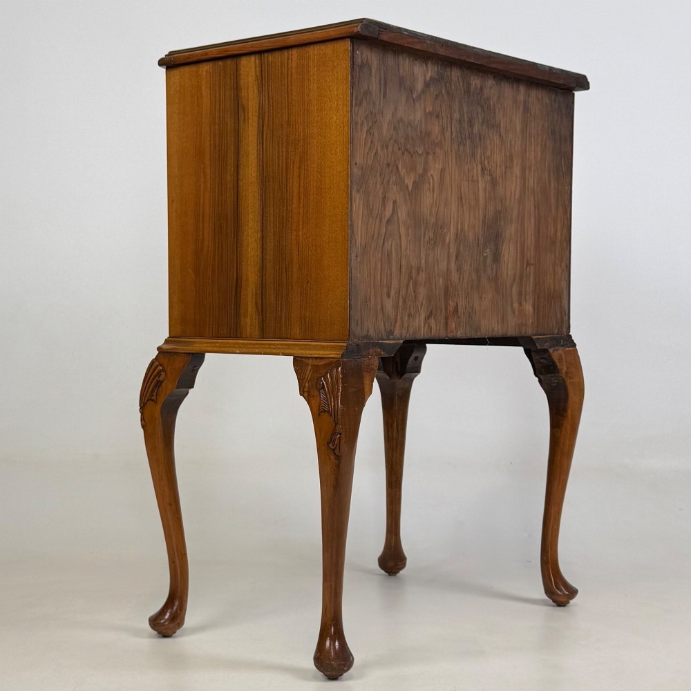 A small 20th-century walnut chest featuring three drawers, brass handles, and tall carved cabriole legs. View IV