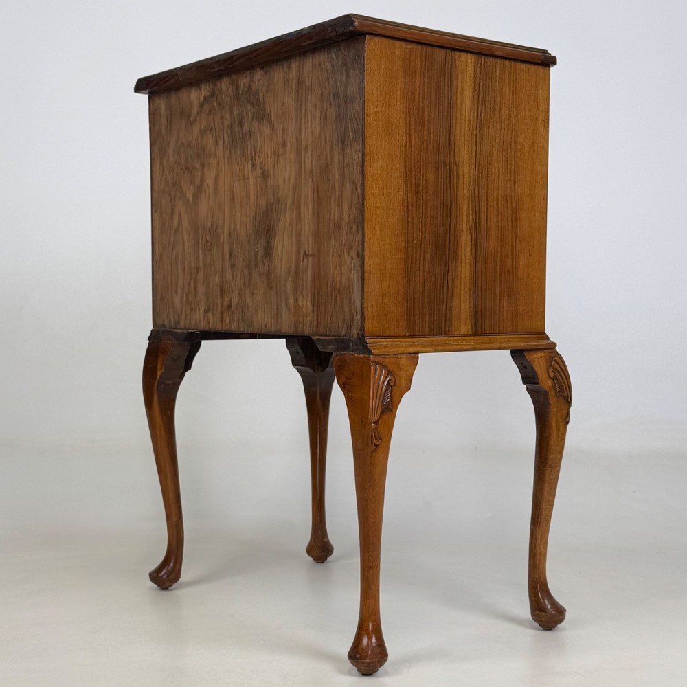 A small 20th-century walnut chest featuring three drawers, brass handles, and tall carved cabriole legs. View VI