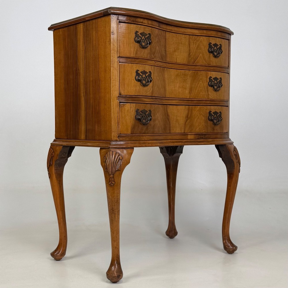 A small 20th-century walnut chest featuring three drawers, brass handles, and tall carved cabriole legs. View VIII