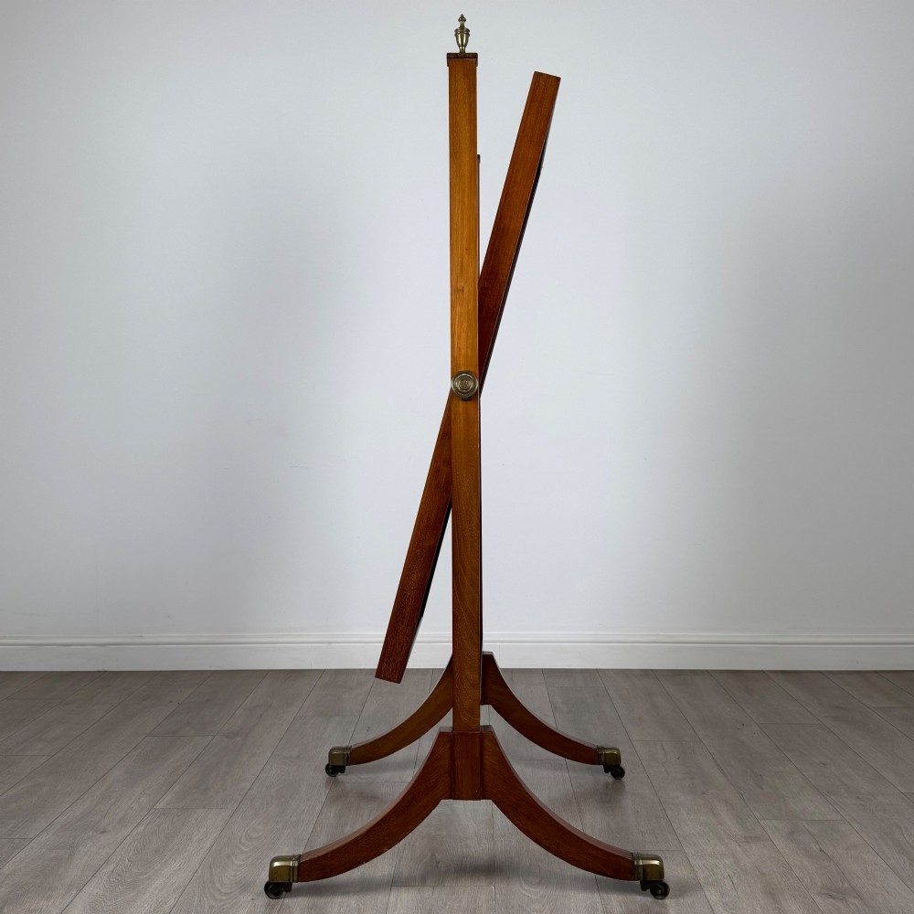 An Edwardian mahogany cheval mirror featuring a rectangular tilting mirror frame set between twin uprights with finials and splayed legs on brass castors. View III