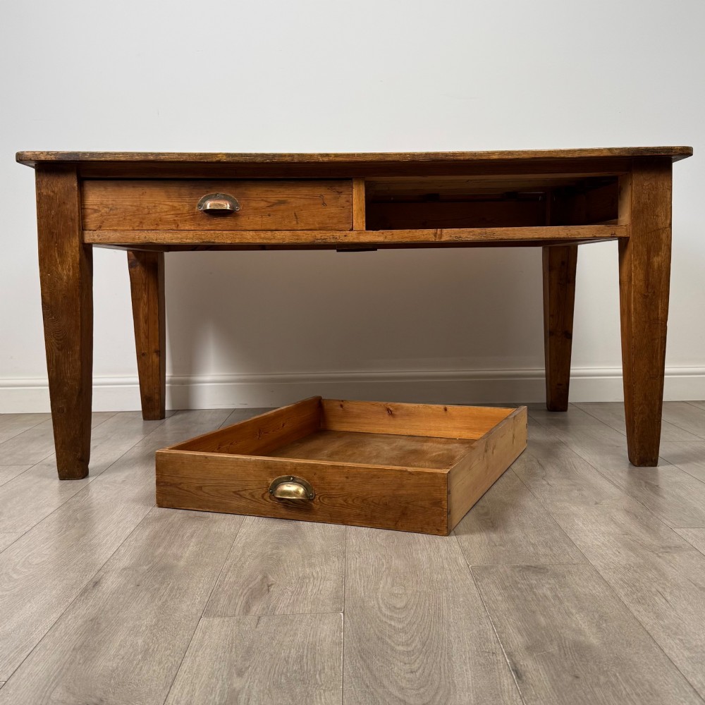 A 19th-century pine writing table featuring two front drawers with brass cup handles and tapered square legs. View X