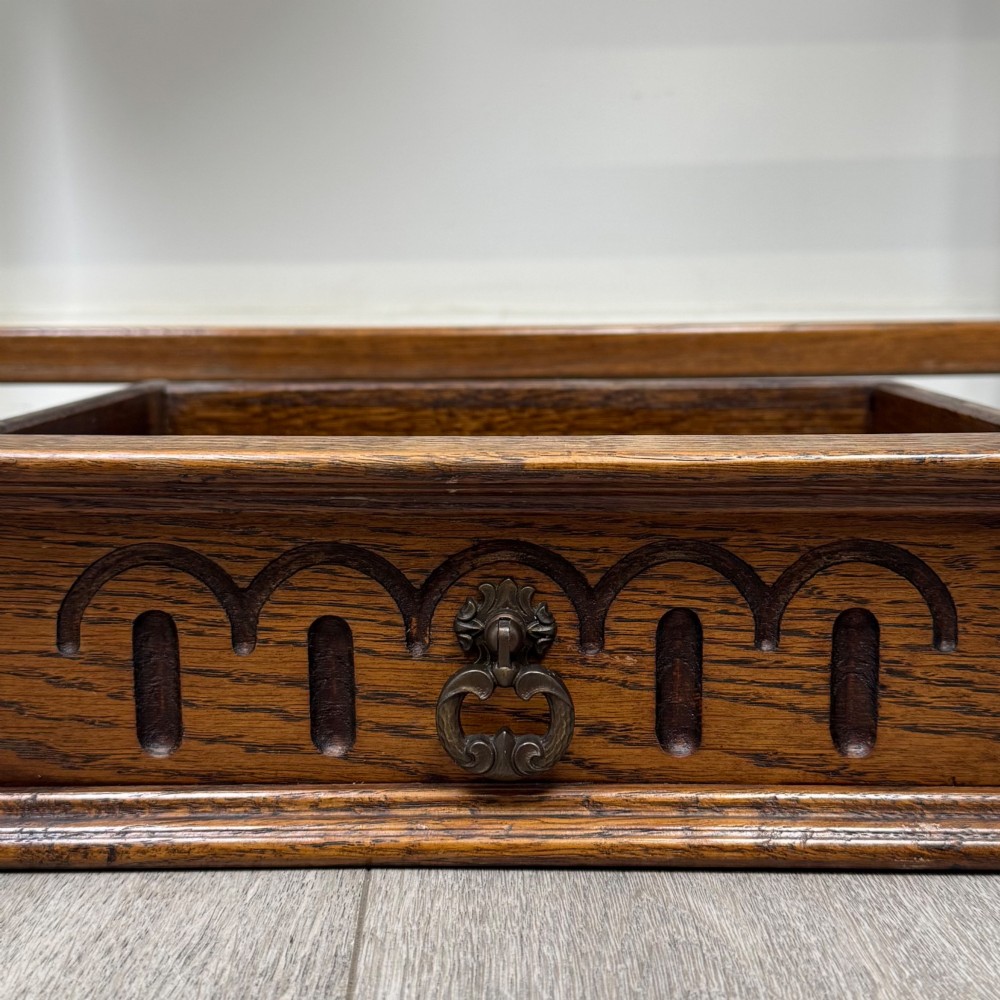 An antique Edwardian dark oak side table featuring two carved front drawers with brass ring pulls and turned legs joined by stretchers. View XI