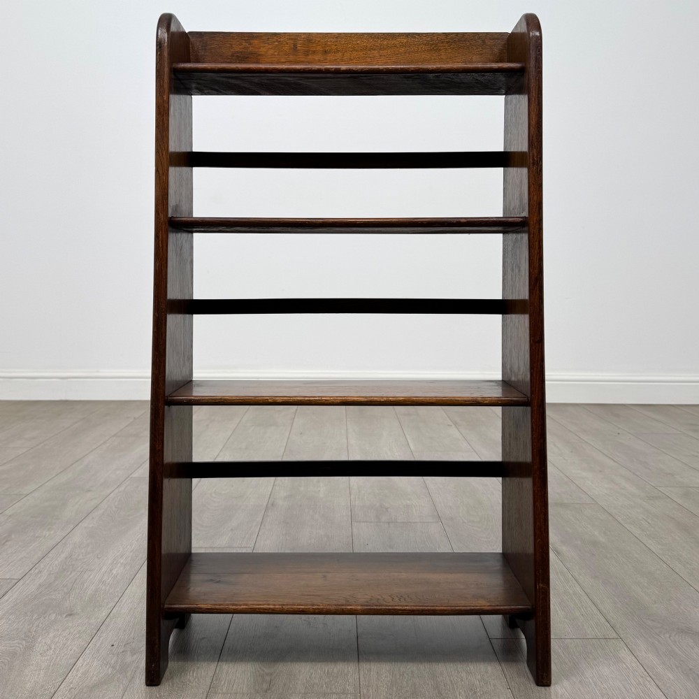 A freestanding early 20th-century warm brown open oak bookcase featuring three fixed shelves and solid side panels. View II