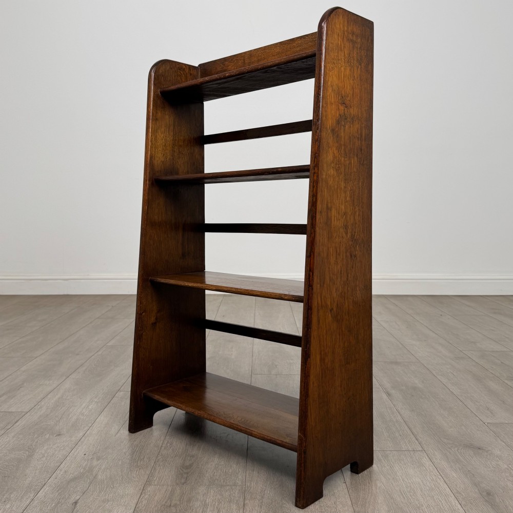 A freestanding early 20th-century warm brown open oak bookcase featuring three fixed shelves and solid side panels. View III