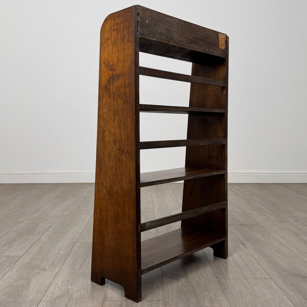 A freestanding early 20th-century warm brown open oak bookcase featuring three fixed shelves and solid side panels. View V