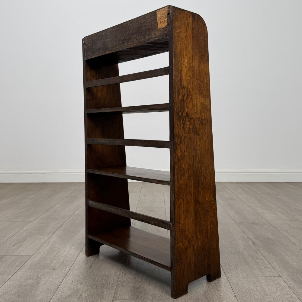 A freestanding early 20th-century warm brown open oak bookcase featuring three fixed shelves and solid side panels. View VII