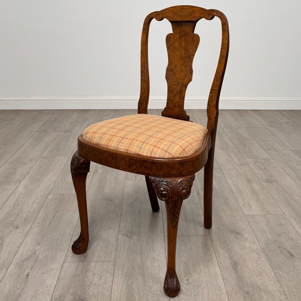 A set of eight Queen Anne revival burr walnut dining chairs featuring carved cabriole legs, claw and ball feet, vasiform splat backs, and patterned upholstered seats. View III