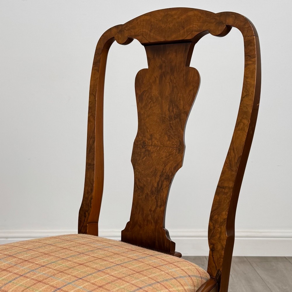 A set of eight Queen Anne revival burr walnut dining chairs featuring carved cabriole legs, claw and ball feet, vasiform splat backs, and patterned upholstered seats. View V