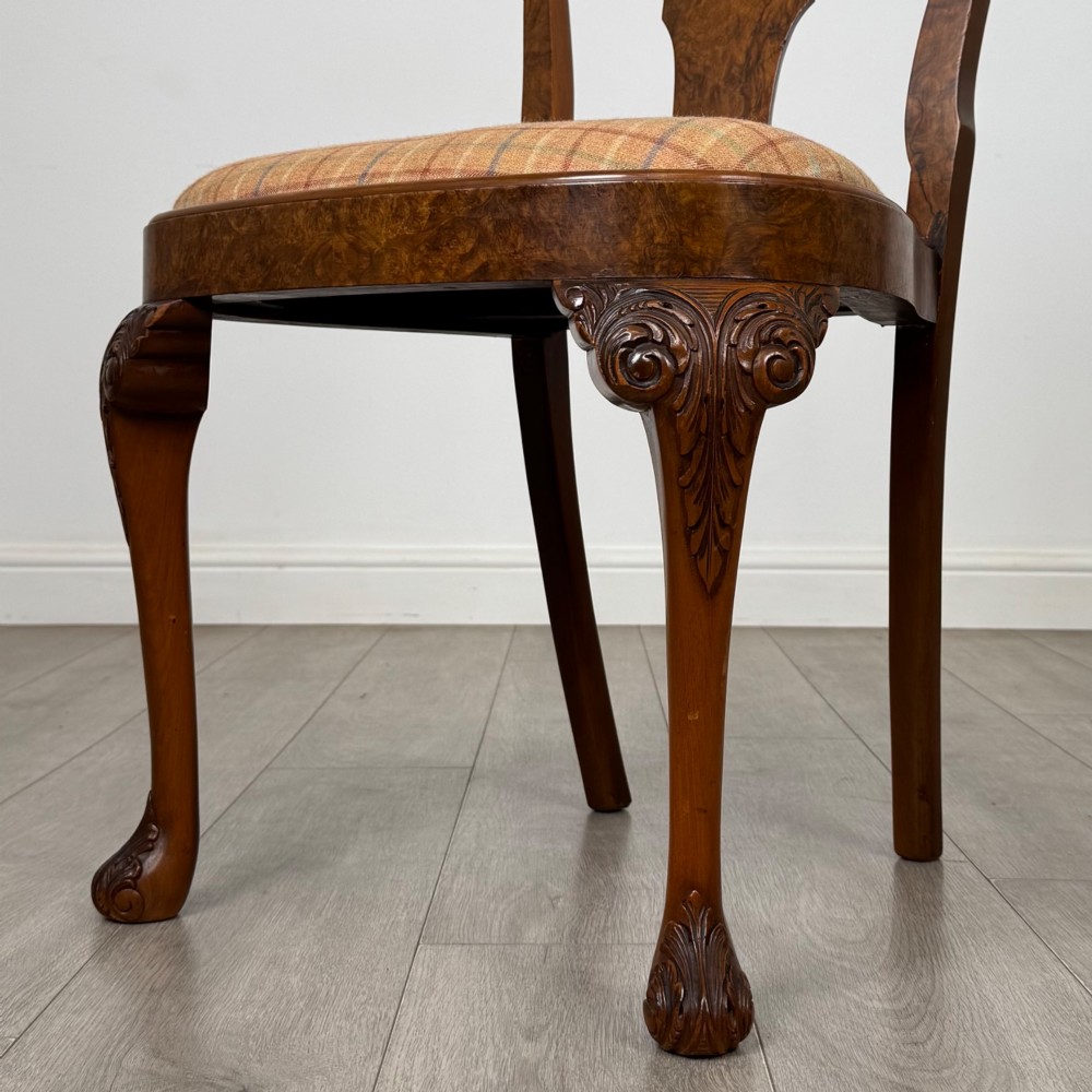 A set of eight Queen Anne revival burr walnut dining chairs featuring carved cabriole legs, claw and ball feet, vasiform splat backs, and patterned upholstered seats. View VI