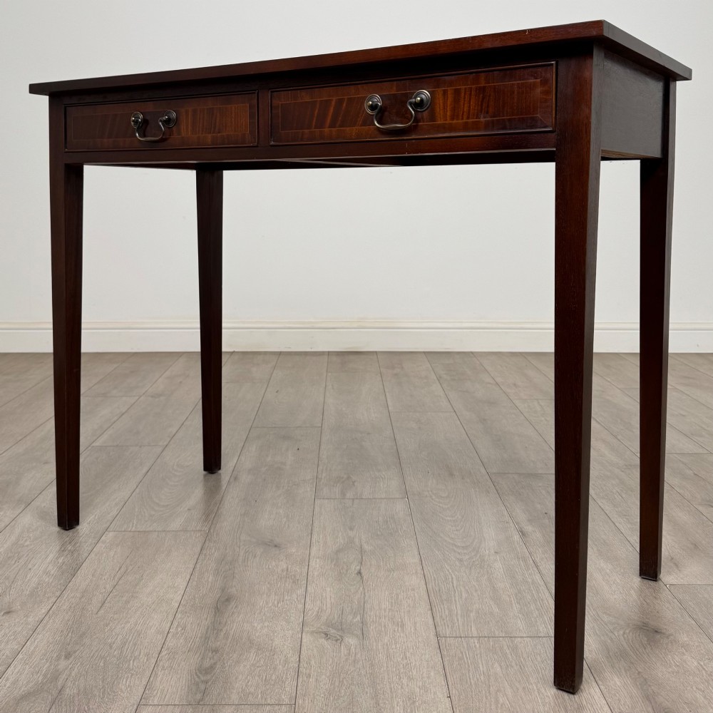 A dark mahogany writing table featuring two frieze drawers with brass swan-neck handles and tapered square legs. View II