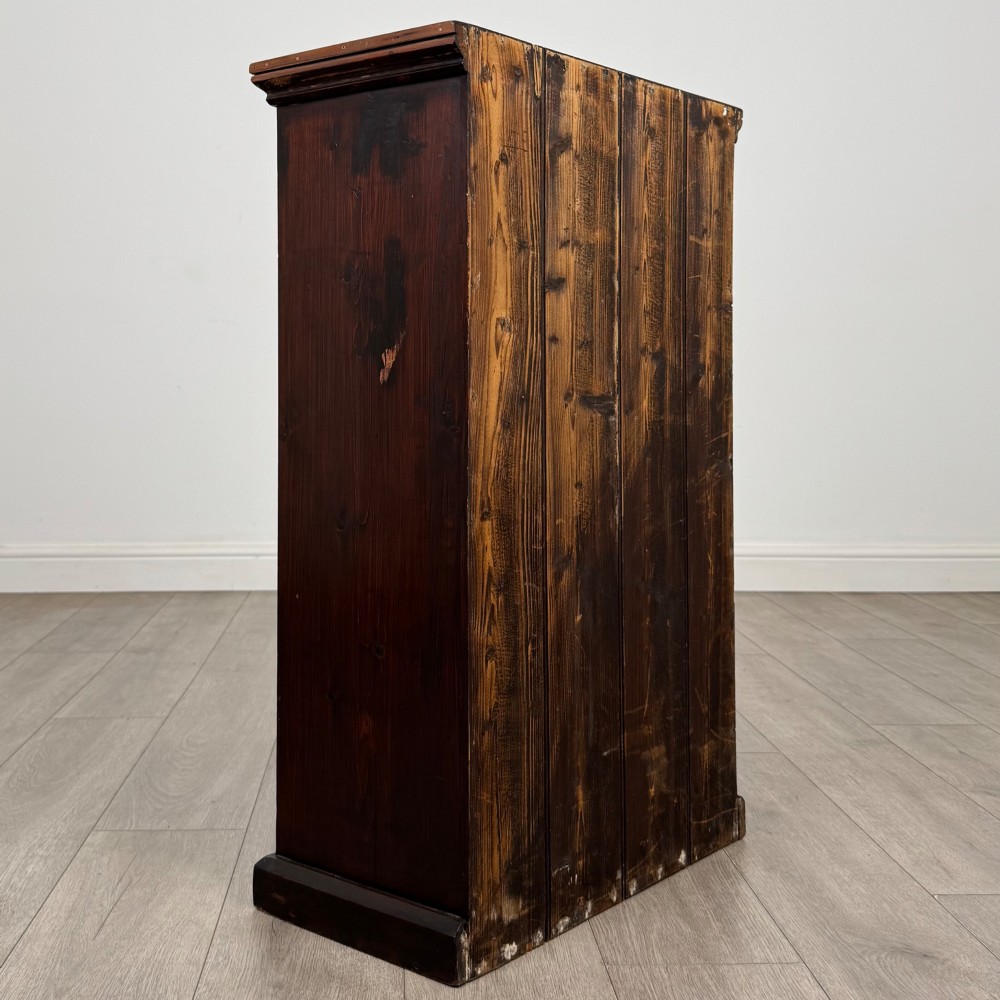 A dark brown stained Edwardian pine glazed cabinet featuring a single glass door with a turned wooden handle and internal shelves. View V