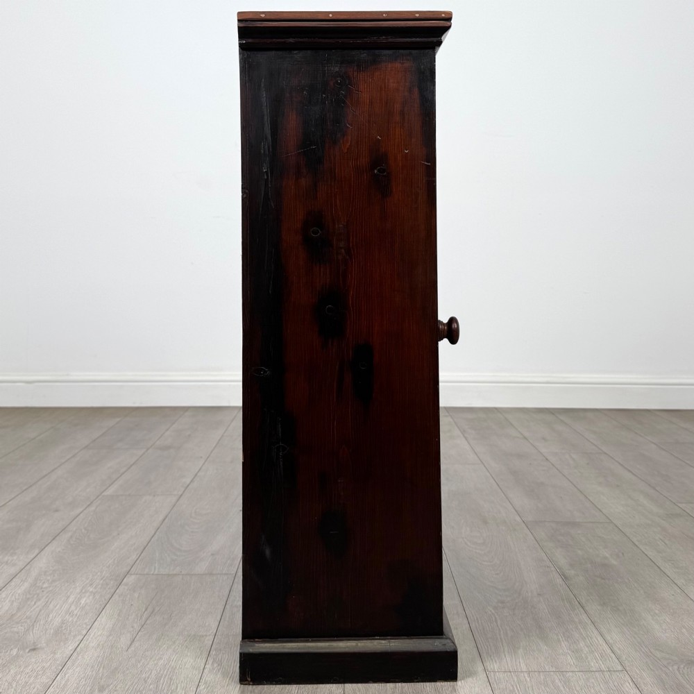 A dark brown stained Edwardian pine glazed cabinet featuring a single glass door with a turned wooden handle and internal shelves. View VIII