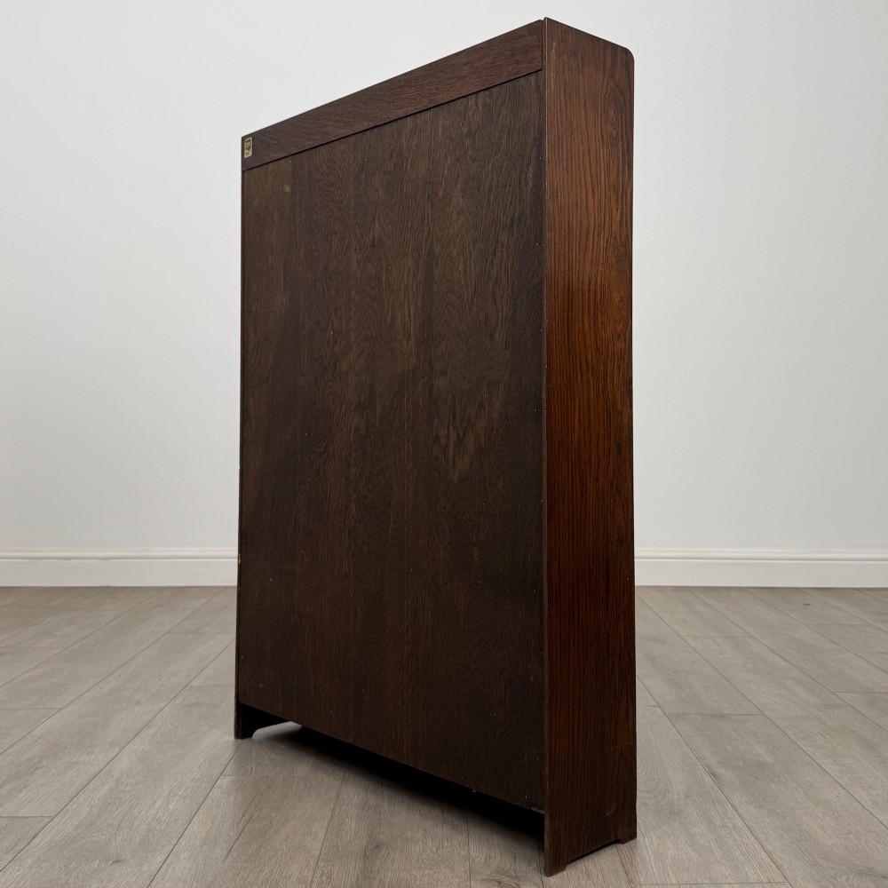 An antique dark oak open bookcase featuring four horizontal shelves with raised side galleries and a solid plinth base. View VII