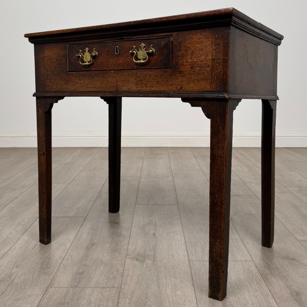 An 18th-century Georgian oak side table featuring a single frieze drawer with brass handles and straight square legs. View II