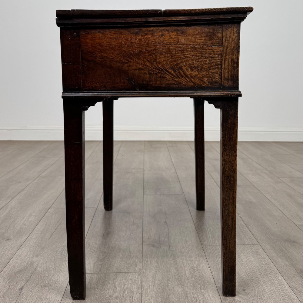 An 18th-century Georgian oak side table featuring a single frieze drawer with brass handles and straight square legs. View VII