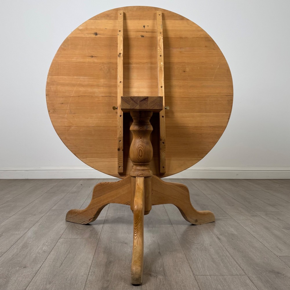 A 19th-century circular pine tilt-top breakfast table with a turned central pedestal column and splayed four-leg base. View III