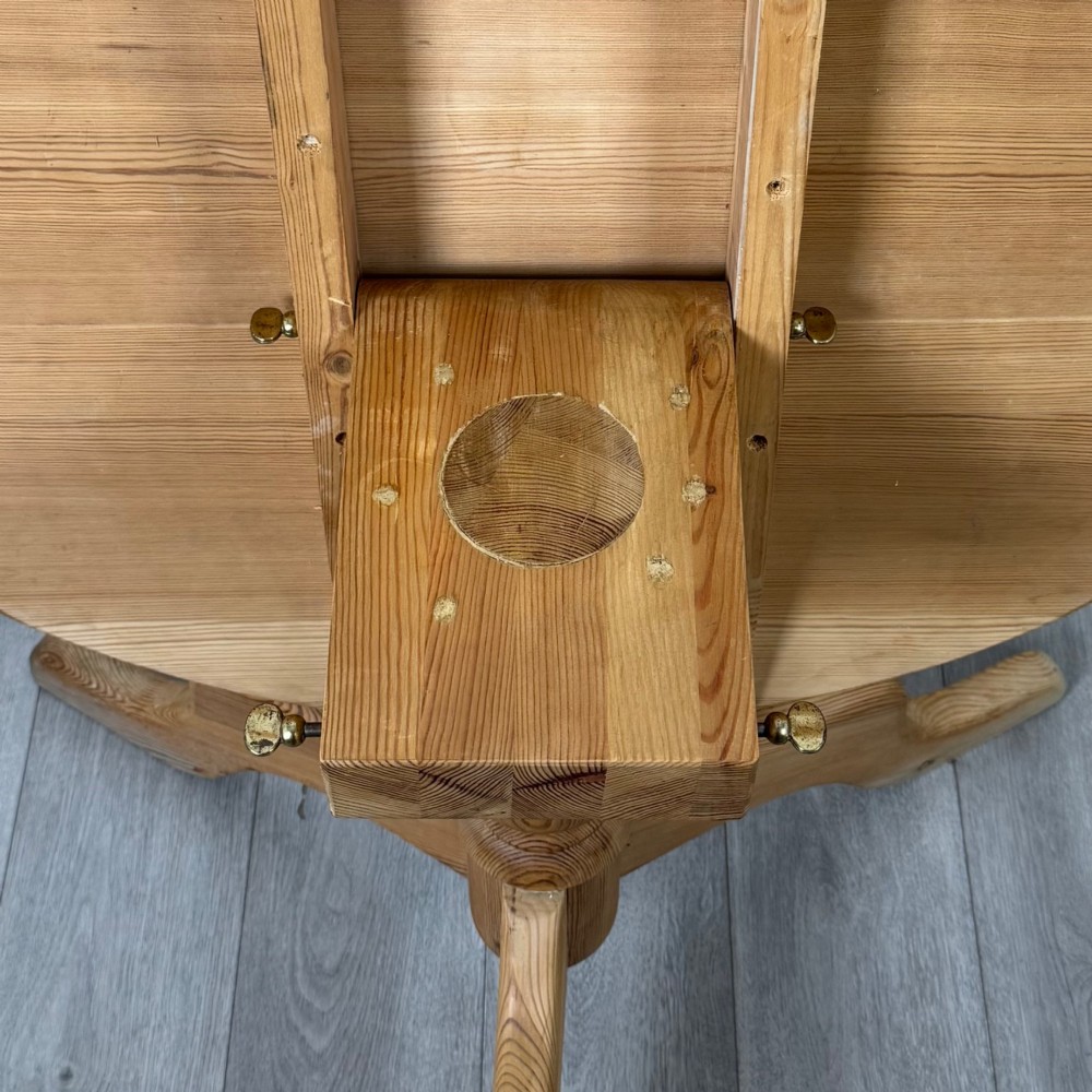 A 19th-century circular pine tilt-top breakfast table with a turned central pedestal column and splayed four-leg base. View IV