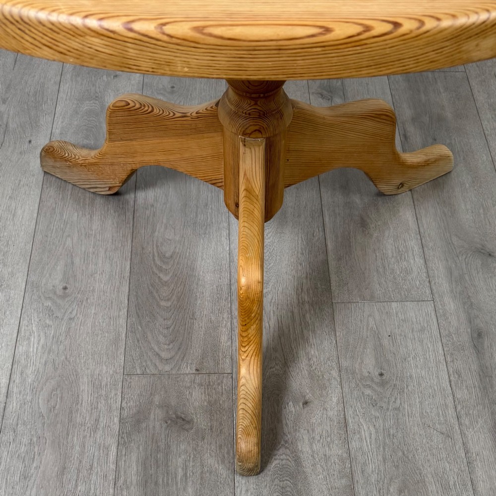 A 19th-century circular pine tilt-top breakfast table with a turned central pedestal column and splayed four-leg base. View V