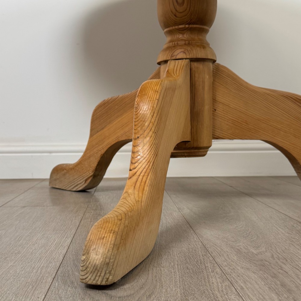 A 19th-century circular pine tilt-top breakfast table with a turned central pedestal column and splayed four-leg base. View VI