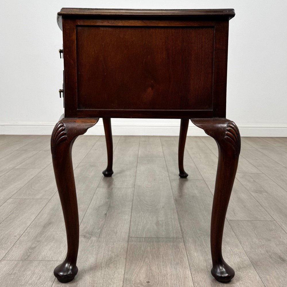 An Edwardian mahogany writing table featuring five drawers with decorative brass handles, a central kneehole apron, and carved cabriole legs. View III