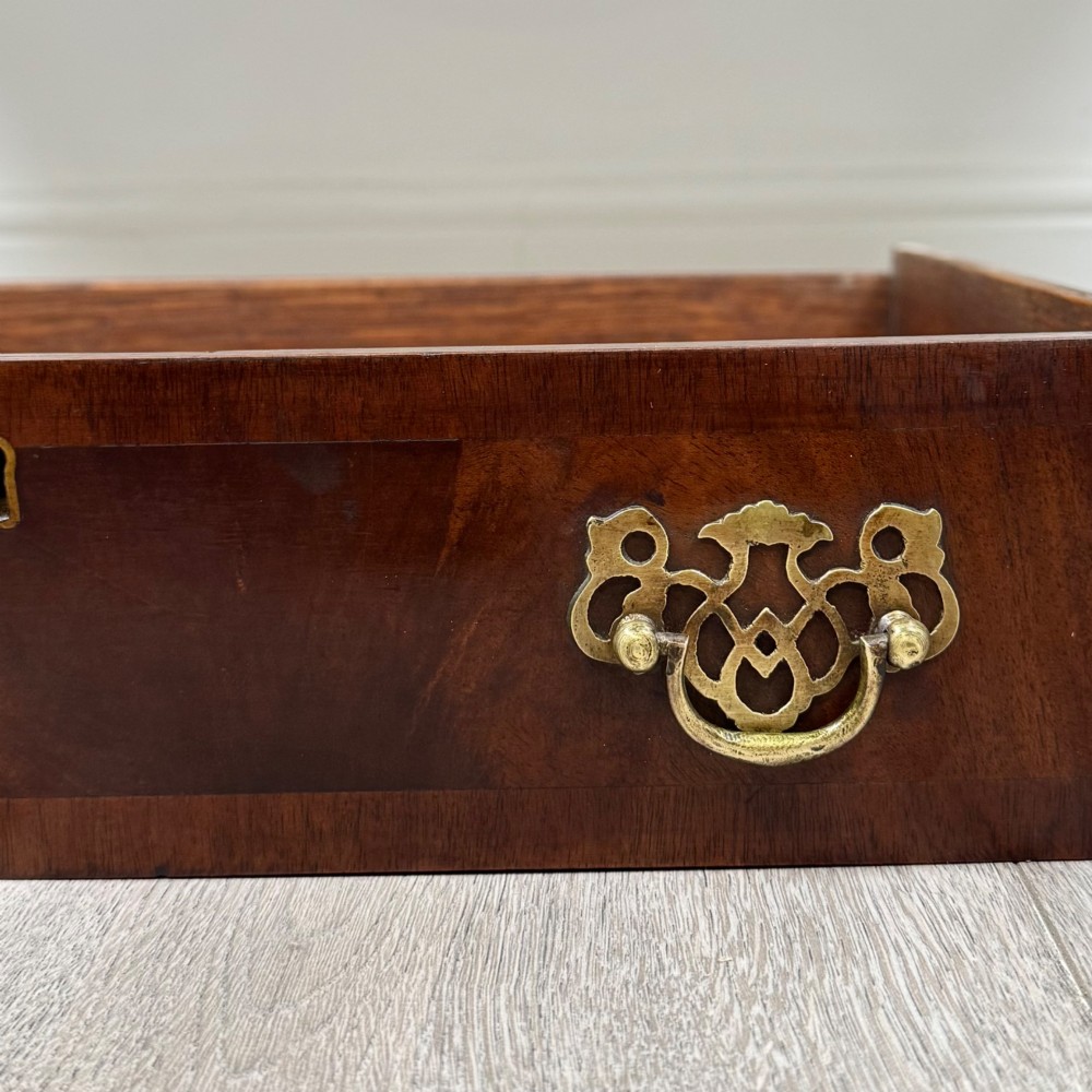 An Edwardian mahogany writing table featuring five drawers with decorative brass handles, a central kneehole apron, and carved cabriole legs. View XI