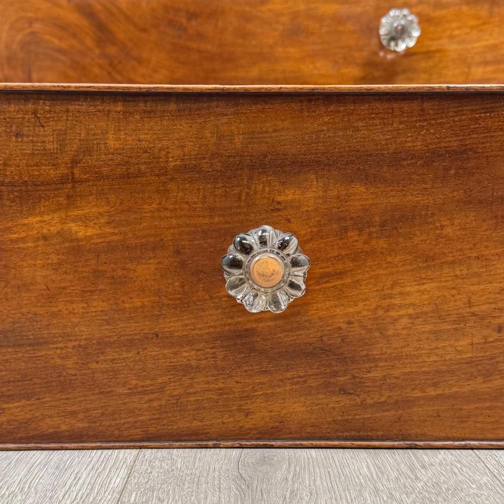 A 19th-century Regency mahogany chest of drawers featuring two short over three long graduated drawers, decorative spiral-twist side columns, glass knobs, and turned carved feet. View XI