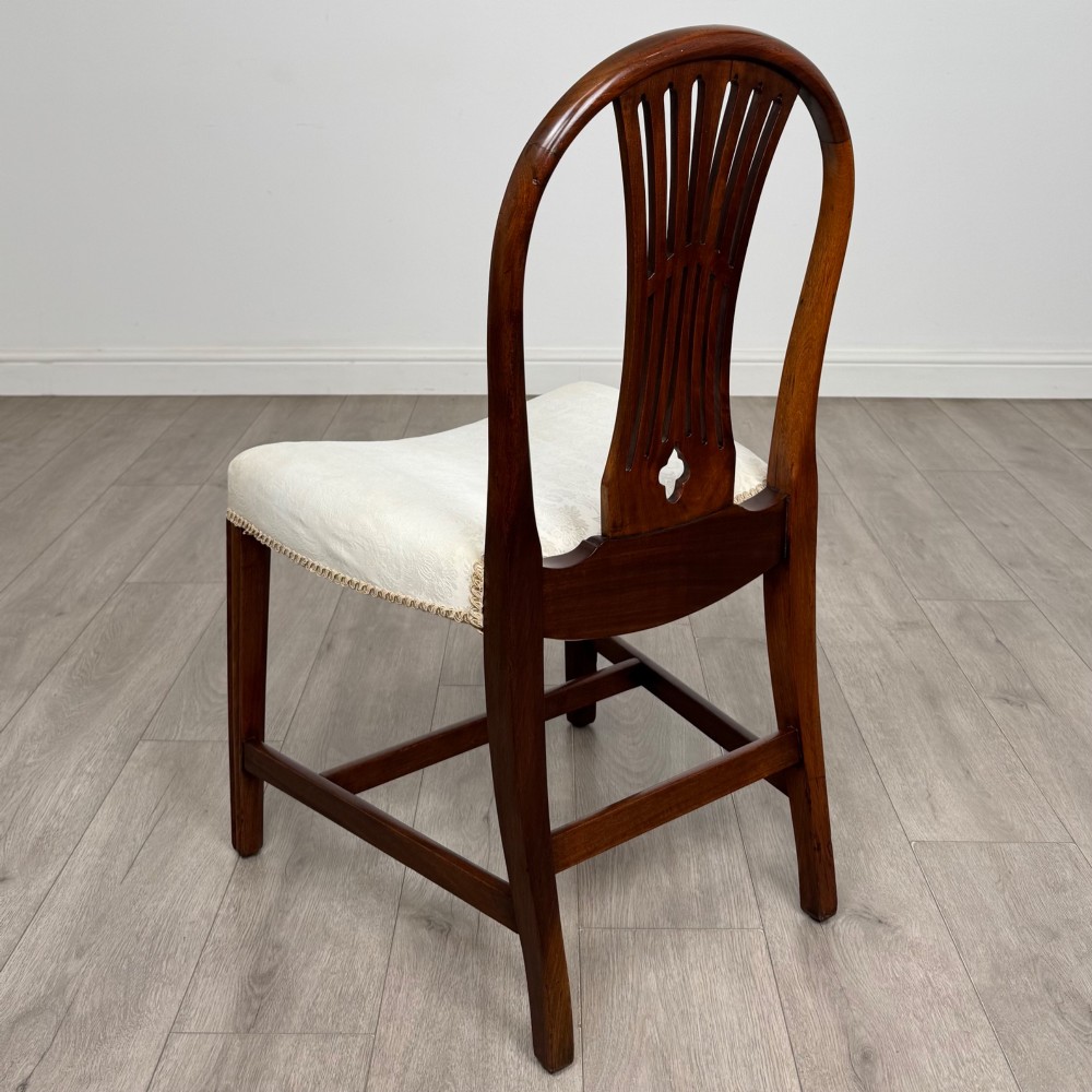 A set of eight 19th-century Hepplewhite style mahogany dining chairs featuring carved openwork back splats, square tapered legs, and light cream upholstered seats. View IV
