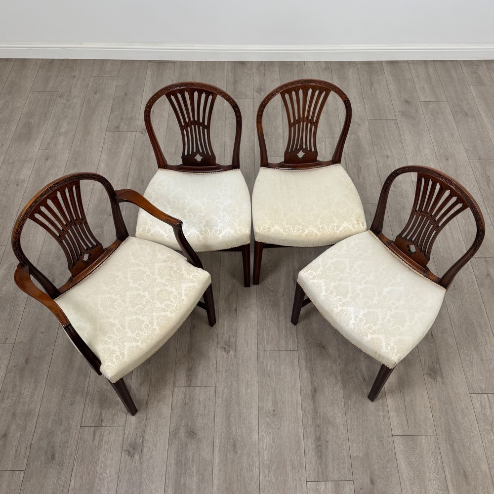 A set of eight 19th-century Hepplewhite style mahogany dining chairs featuring carved openwork back splats, square tapered legs, and light cream upholstered seats. View VIII
