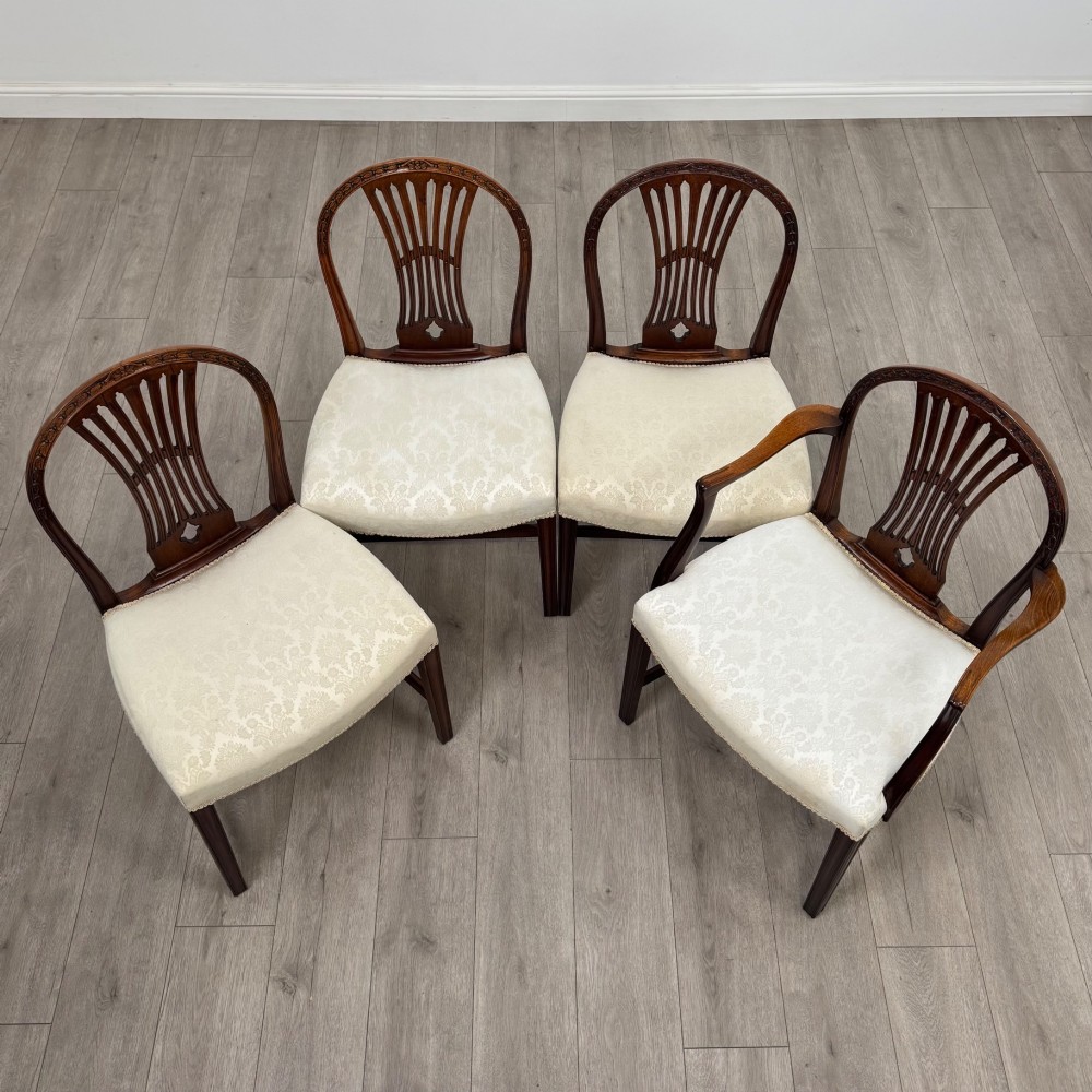 A set of eight 19th-century Hepplewhite style mahogany dining chairs featuring carved openwork back splats, square tapered legs, and light cream upholstered seats. View IX