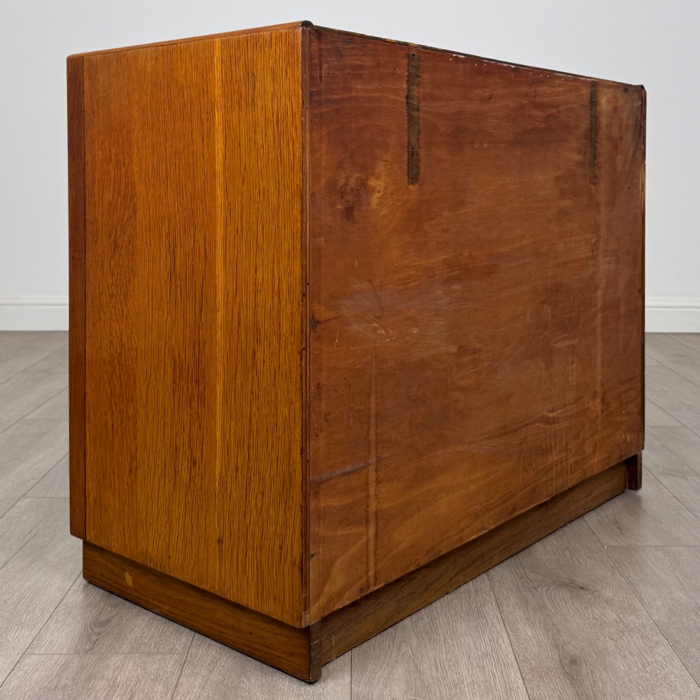 A golden oak chest of four full-width drawers featuring wooden bar handles and a solid plinth base. View IV