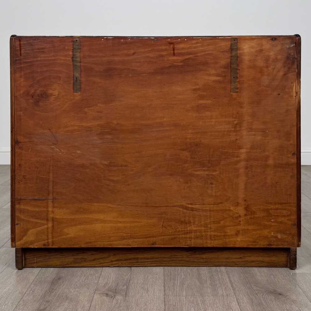 A golden oak chest of four full-width drawers featuring wooden bar handles and a solid plinth base. View V