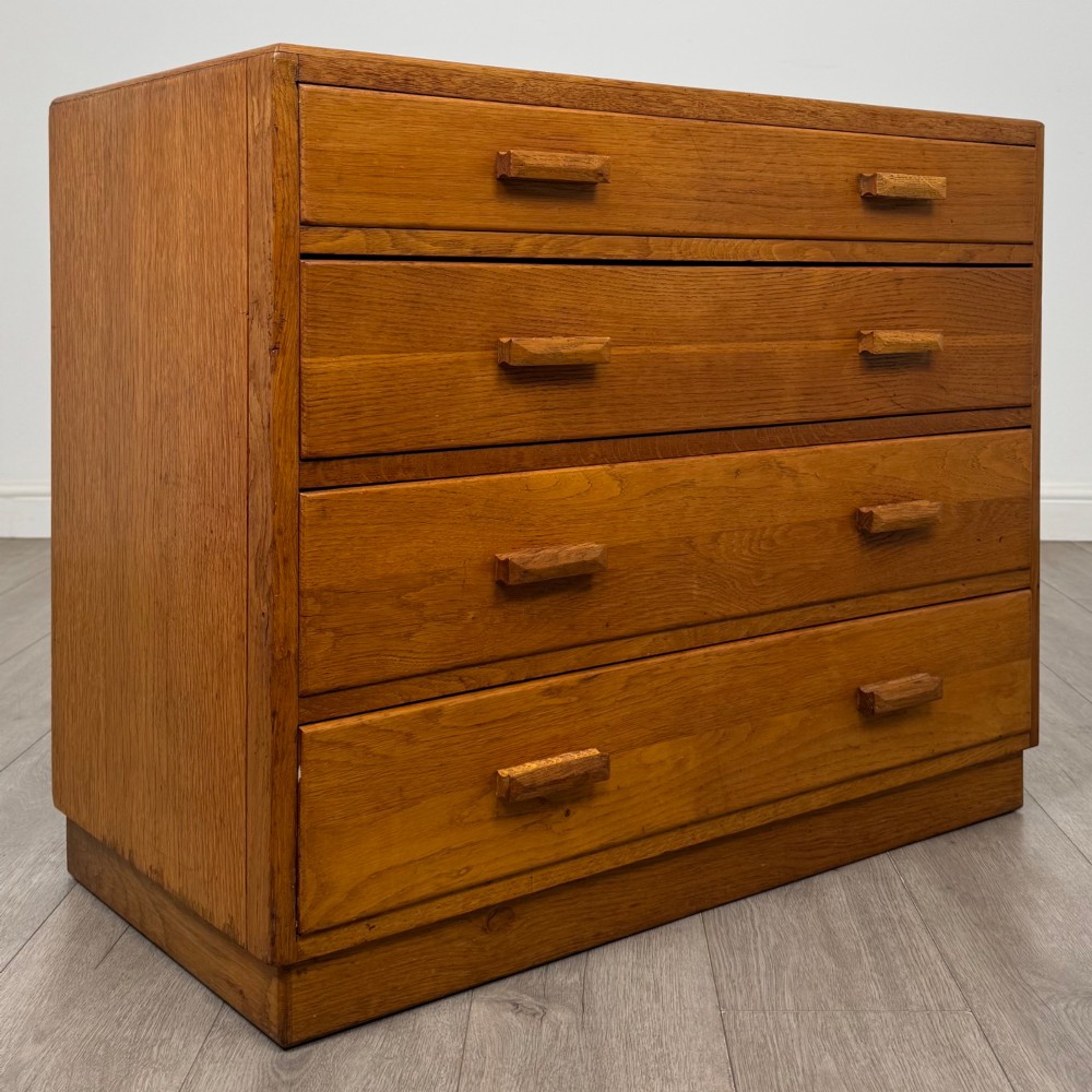 A golden oak chest of four full-width drawers featuring wooden bar handles and a solid plinth base. View VIII